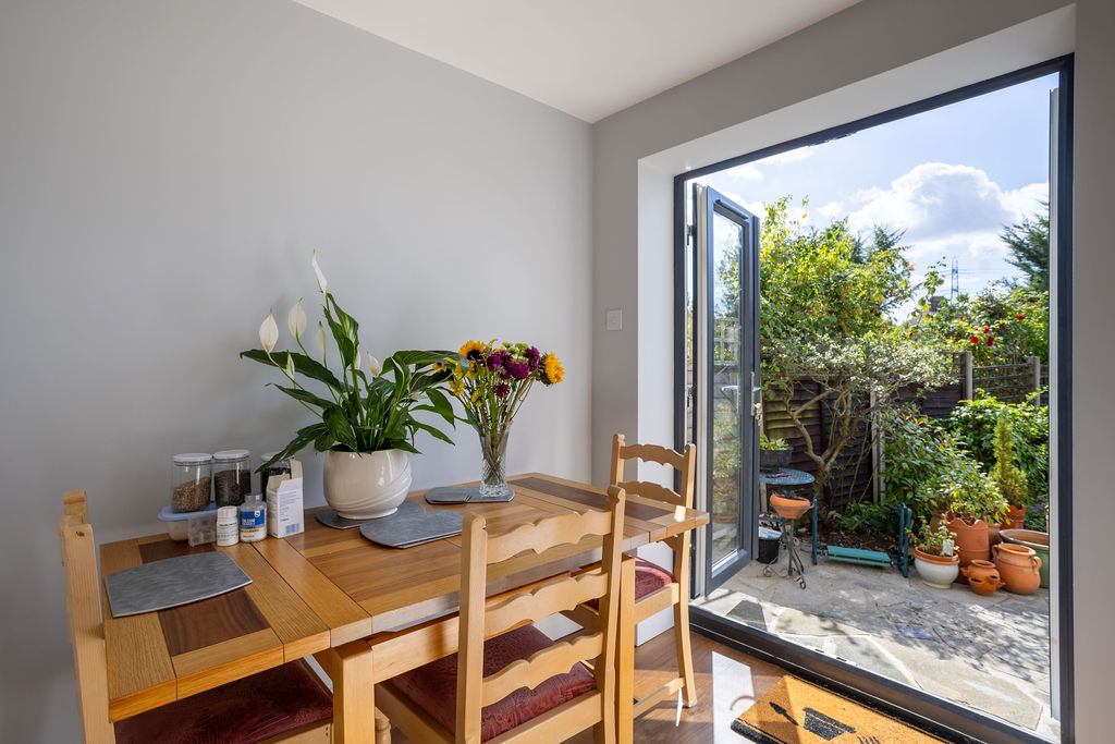 A completed Plan Hub project: a sunlit dining space opening to the garden through full-height doors.